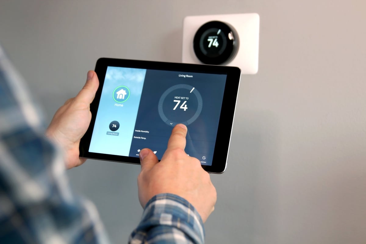 Man adjusting temperature with a tablet in modern living room