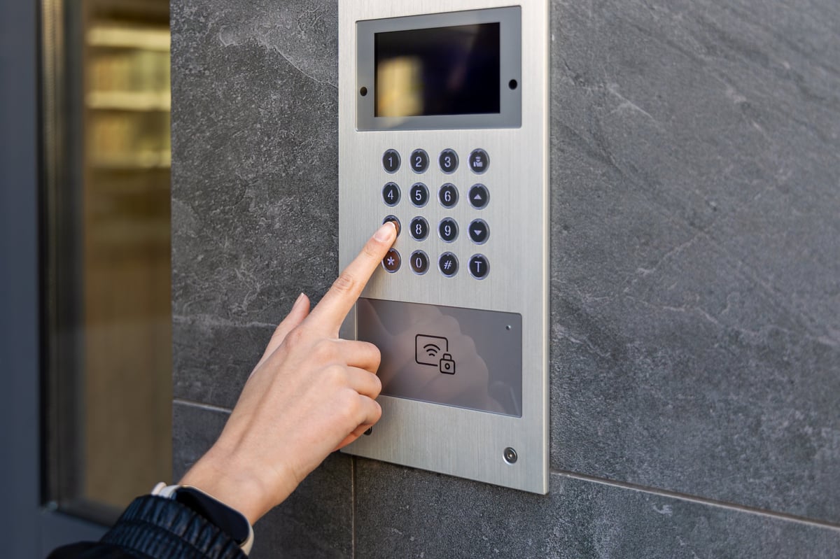 Hand pressing keypad on video intercom panel